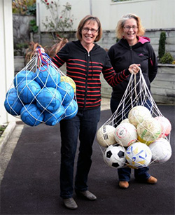 HUFC Equipment Manager Rochelle Middleton (right) with Kuli Library Project volunteer Betty-Anne Kamp, and the donated balls.